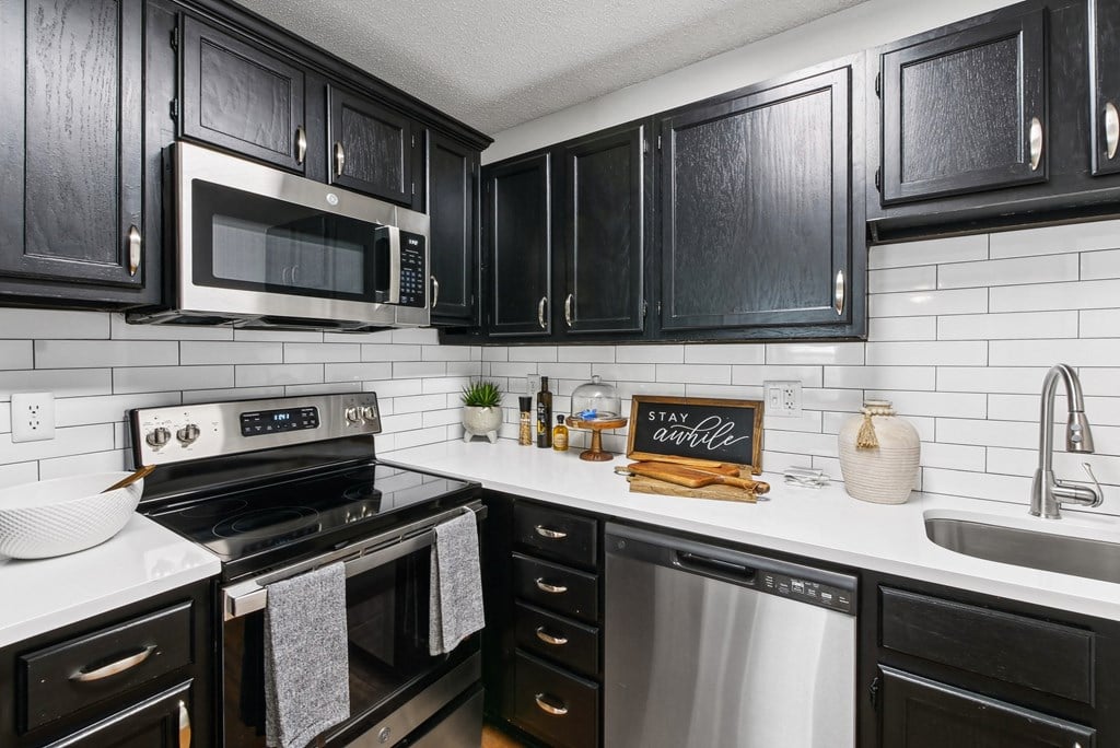 Renovated Kitchen A kitchen with black cabinets and a white backsplash at Elme Druid Hills, Atlanta, Georgia